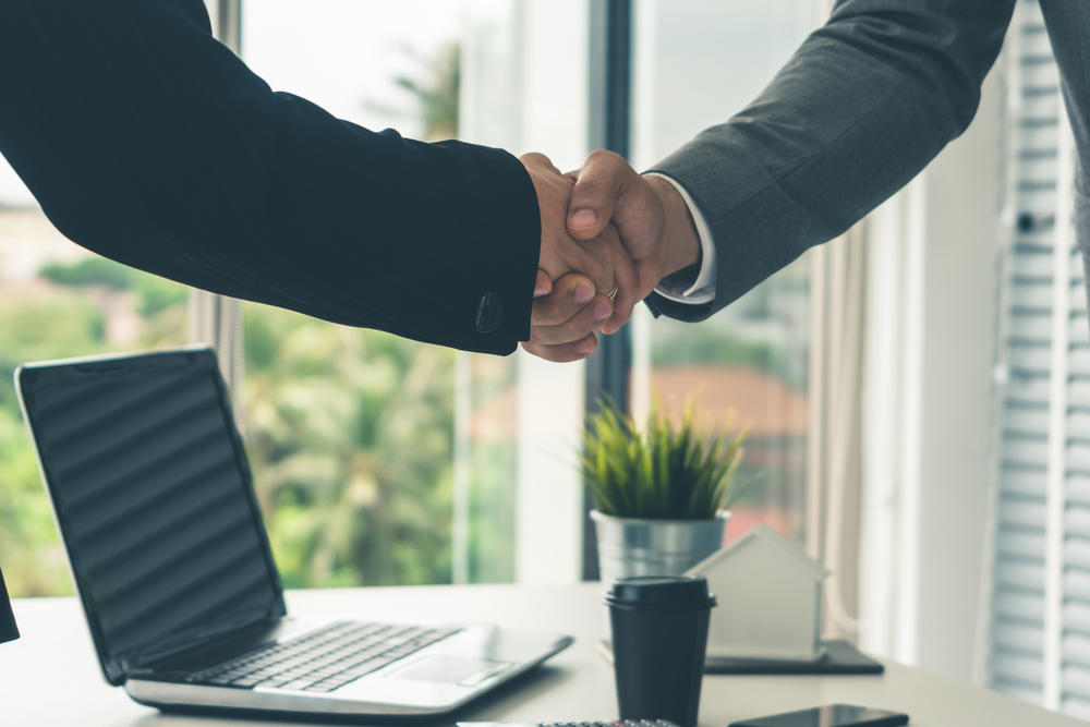 Businessman handshake businesswoman in office.
